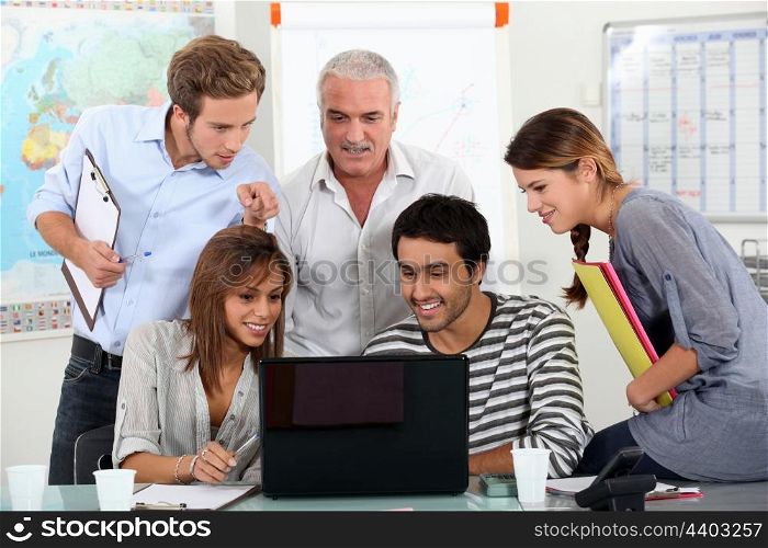 Students showing video to teacher on laptop computer