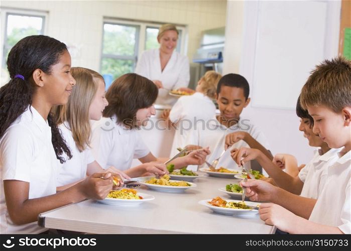 Students sitting at cafeteria table eating lunch (depth of field)