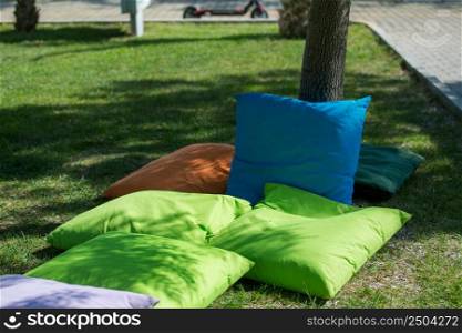 Students sitting on cushions under trees