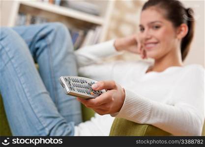Students - Smiling female teenager watching television in living room