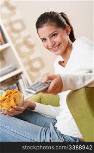 Students - Smiling female teenager watching television in living room