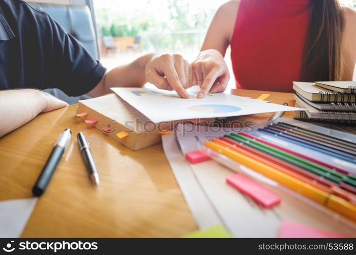 students studying and learning in a coffee shop with a laptop and notes.