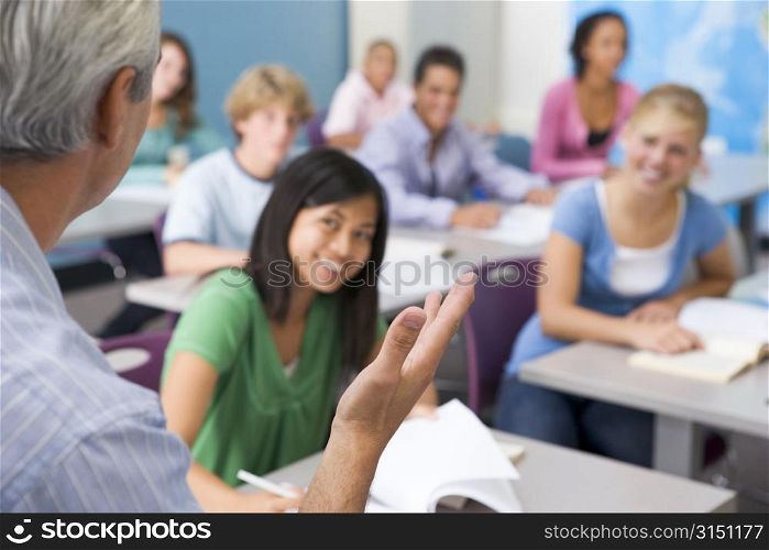 Students studying in geography class with teacher