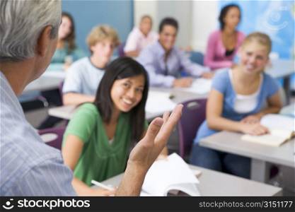 Students studying in geography class with teacher