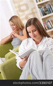 Students - Two female students studying in lounge, reading book