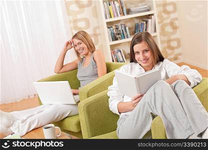 Students - Two female students studying in lounge, reading book