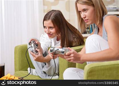 Students - Two female teenager playing video TV game in modern living room