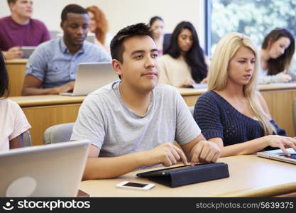 Students Using Laptops And Digital Tablets In Lecture