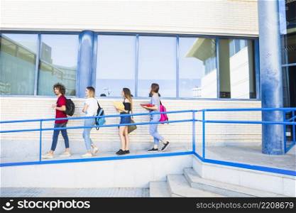 students walking ramp near university building