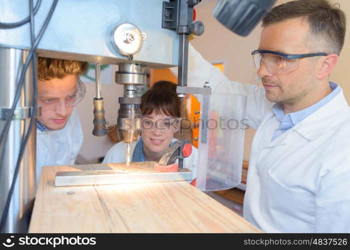 Students watching instructor use bench drill