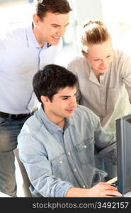 Students with teacher in front of desktop computer