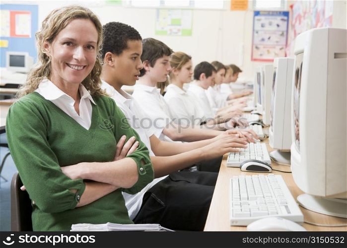 Students working on computer workstations with teacher
