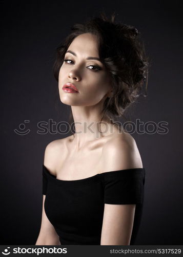 Studio art portrait of beautiful woman with elegant hairstyle on black background