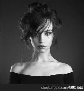 Studio art portrait of beautiful woman with elegant hairstyle on black background