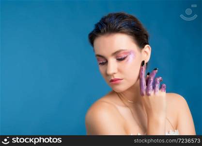 Studio beauty portrait of attractive woman with creative make-up and glitter and spangle on her face and hands.Face art.. Studio beauty portrait of attractive woman with creative make-up