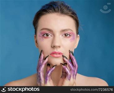 Studio beauty portrait of attractive woman with creative make-up and glitter and spangle on her face and hands.Face art.. Studio beauty portrait of attractive woman with creative make-up