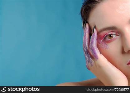 Studio beauty portrait of attractive woman with creative make-up and glitter and spangle on her face and hands.Face art.Half,cut face.. Studio beauty portrait of attractive woman with creative make-up