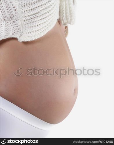 Studio close up of a beautiful pregnant belly on white background