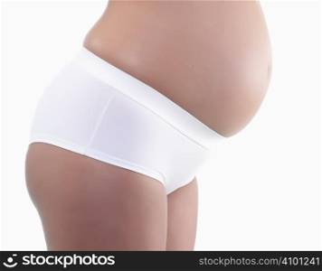 Studio close up of a beautiful pregnant belly on white background
