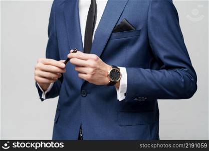studio close-up photo of young businessman wearing suit holding pen. close-up photo of young businessman wearing suit holding pen