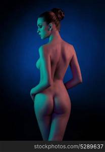 Studio fashion art photo of elegant nude model in the light colored spotlights