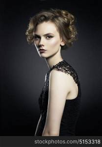 Studio fashion photo of beautiful young lady on black background. Classic studio portrait. Elegant hairstyle