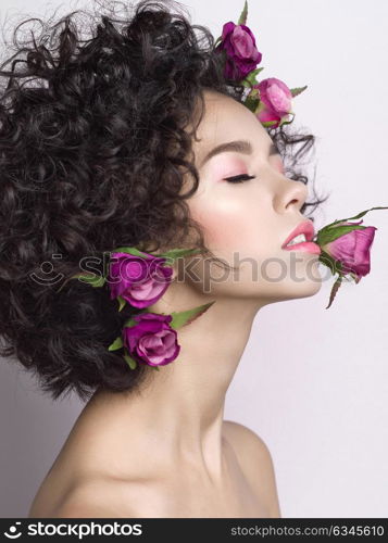 Studio fashion photo of beautiful young woman with flowers in her mouth and hair. Valentines day. Spring blossom