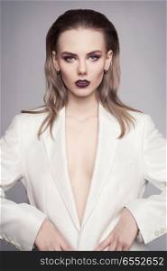 Studio fashion photo of young elegant woman in white men&rsquo;s jacket. Fashion and style. Perfect makeup