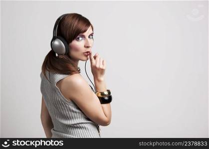 Studio fashion portrait of a young woman listen music