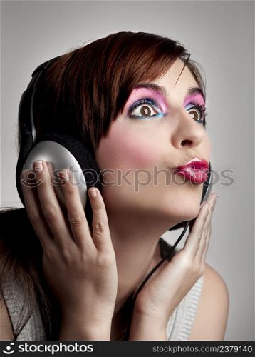 Studio fashion portrait of a young woman posing with a extreme makeup