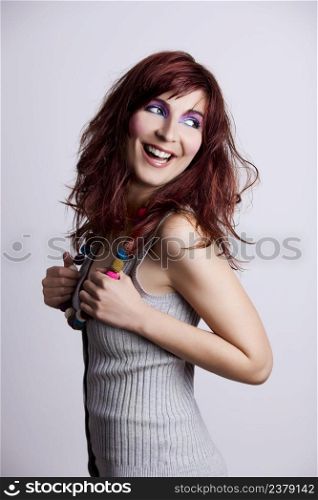 Studio fashion portrait of a young woman posing with a extreme makeup