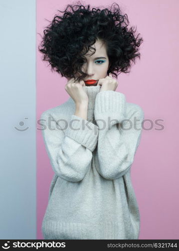 Studio fashion portrait of beautiful asian woman in oversize pullover on colorful pastel background. Stylish look book. Autumn Winter season. Bright spring