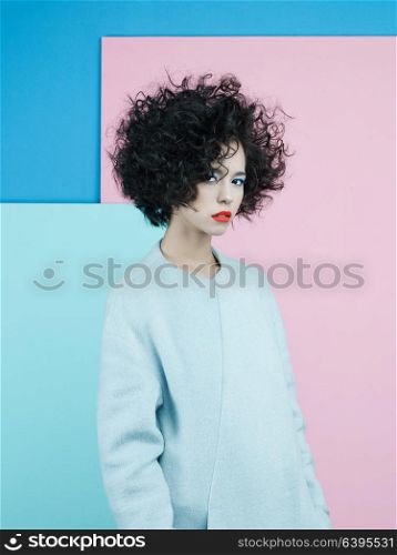 Studio fashion portrait of beautiful asian woman in sky-blue coat on colorful pastel background. Stylish look book. Autumn Winter season. Bright spring