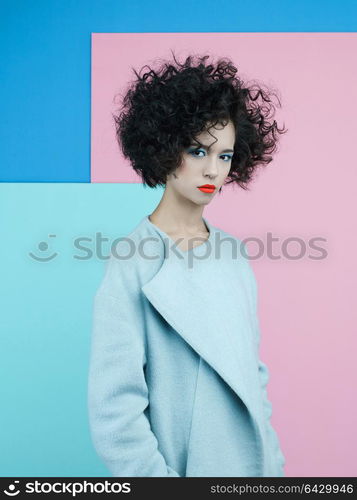 Studio fashion portrait of beautiful asian woman in sky-blue coat on colorful pastel background. Stylish look book. Autumn Winter season. Bright spring