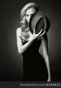 Studio fashion portrait of beautiful lady with hat in her hand