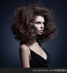 Studio fashion portrait of beautiful woman with volume wavy hair. Big hair