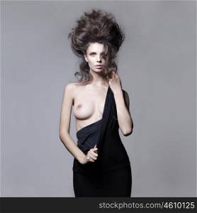 Studio fashion portrait of nude sensual woman with volume wavy hair. Big hair