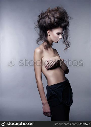 Studio fashion portrait of nude sensual woman with volume wavy hair. Big hair