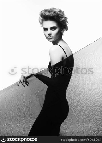Studio fashion portrait of young beautiful lady in evening black dress. Elegant sexy woman with stylish haircut. Fashion female portrait of model with art smoky-eyes makeup.