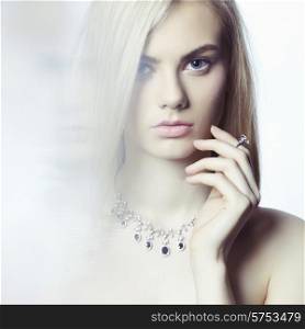 Studio fashion portrait of young beautiful lady in jewelry
