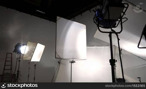 Studio light and back drop and soft box set up for shooting photo or video production which includes flashlight and continue lighting on tripod and paper background and used for photographer or videographer