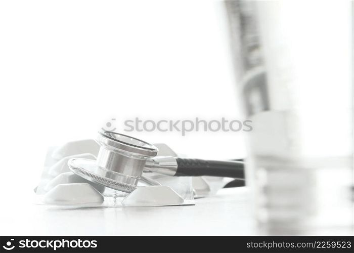 Studio macro of a stethoscope and pills on wood table background copy space
