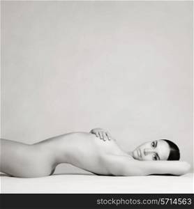 studio photo of elegant naked lady laying on white background