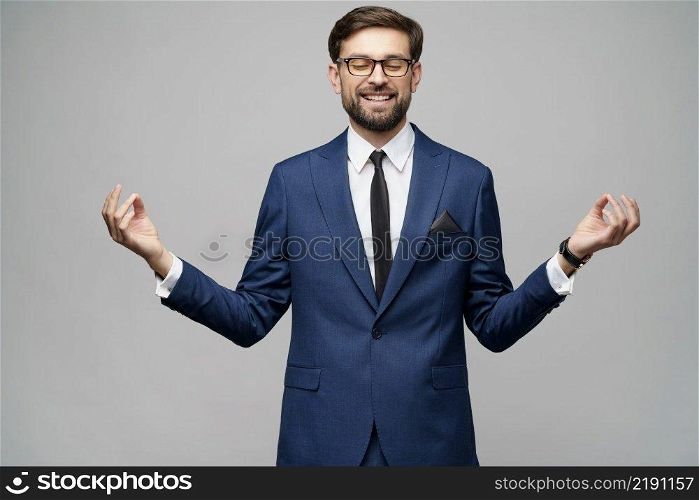 studio photo of meditative young caucasian handsome stylish businessman wearing suit. studio photo of meditative young handsome stylish businessman wearing suit