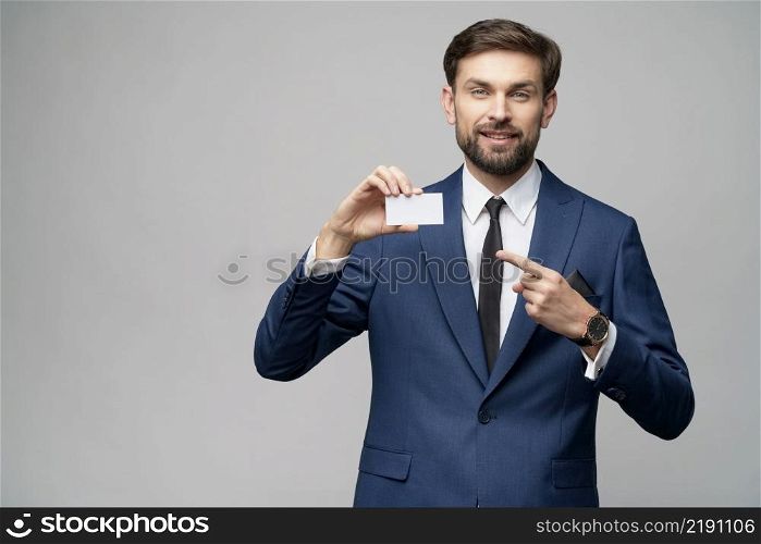 studio photo of young handsome businessman holding business or credit card. young handsome businessman holding business or credit card