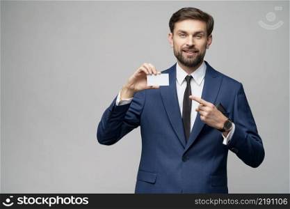 studio photo of young handsome businessman holding business or credit card. young handsome businessman holding business or credit card