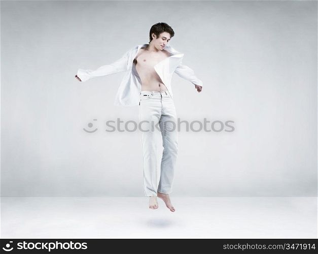 Studio photos of a young man in a jump in a white room