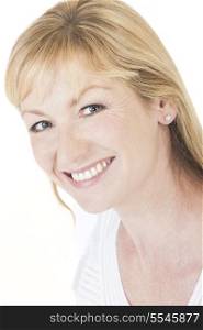 Studio portrait head shot of a happy smiling attractive middle aged blonde woman with perfect teeth
