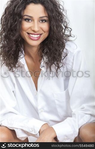 Studio portrait of a beautiful happy young woman smiling wearing an oversized men&rsquo;s white shirt