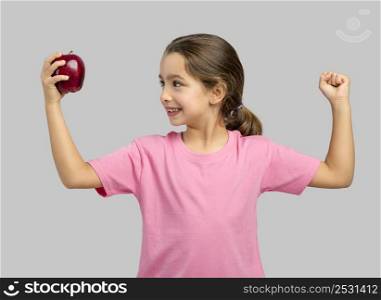 Studio portrait of a beautiful little girl holding a fresh red apple